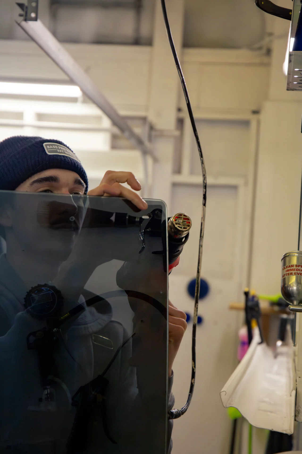 Heat-shrinking window tint film with a heat gun to fit curved glass