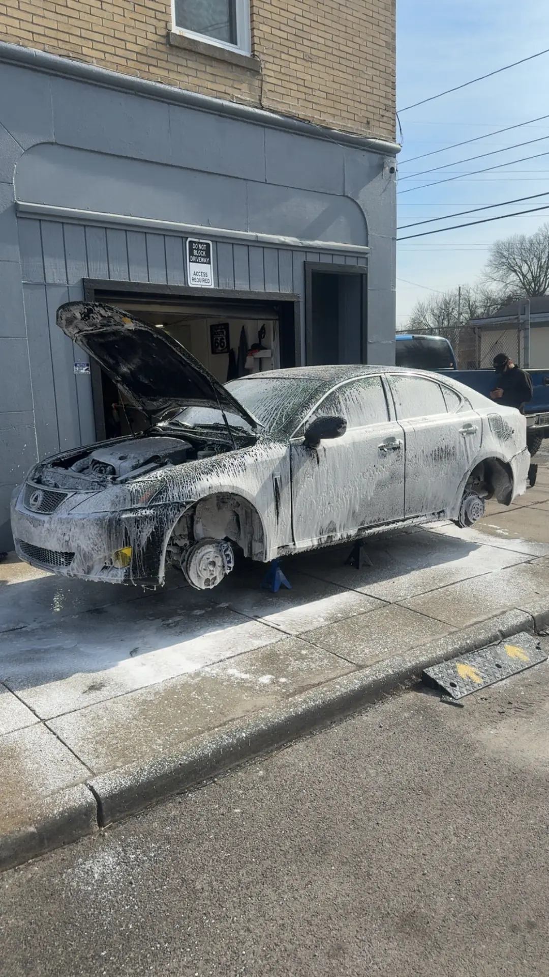 Sedan covered in wash foam during an exterior auto detail