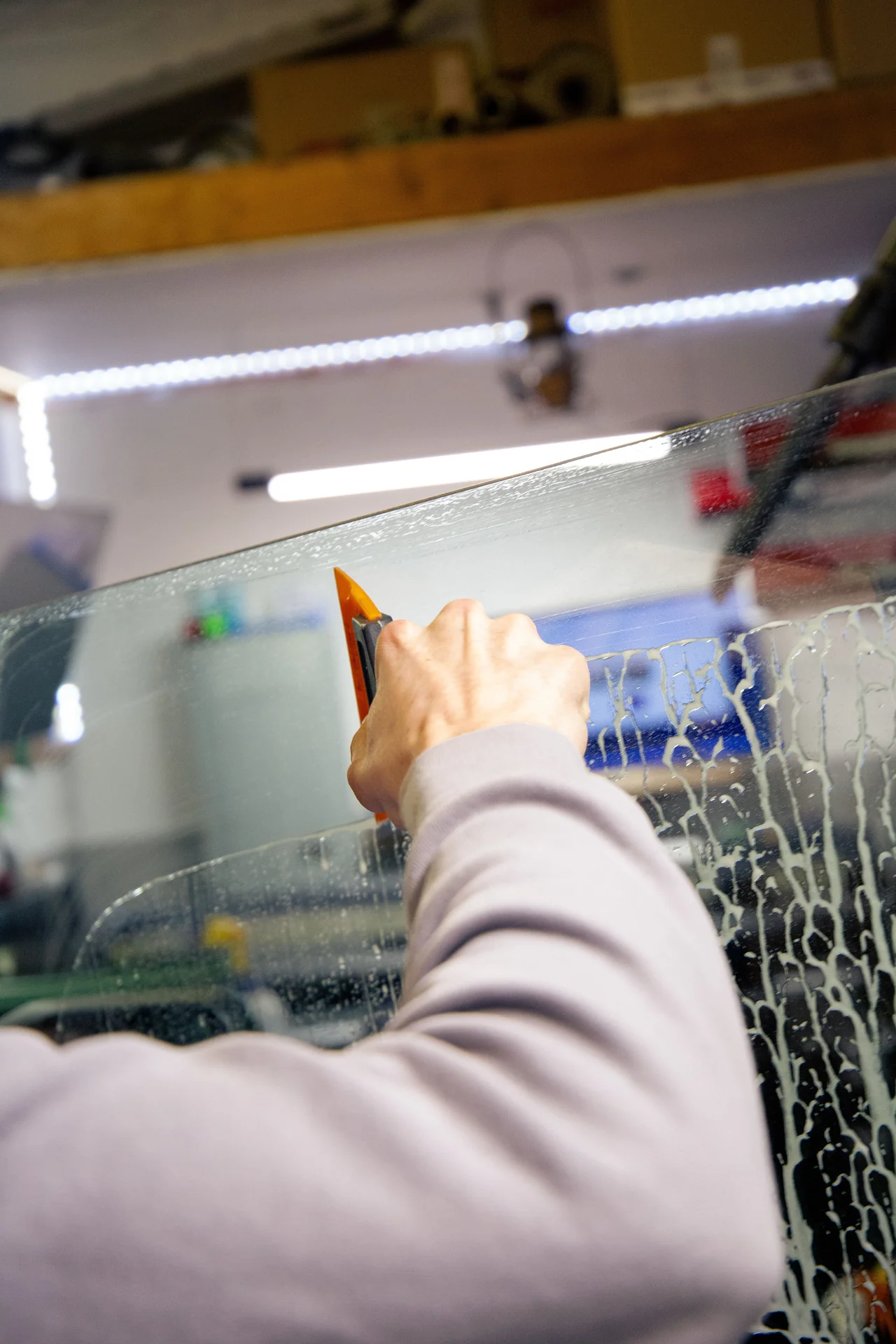 Squeegeeing wet window tint film onto glass