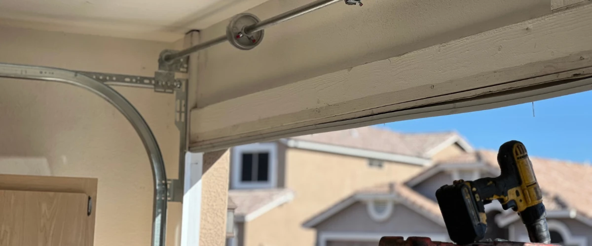 Close-up view of a garage door torsion spring mounted above the door frame.
