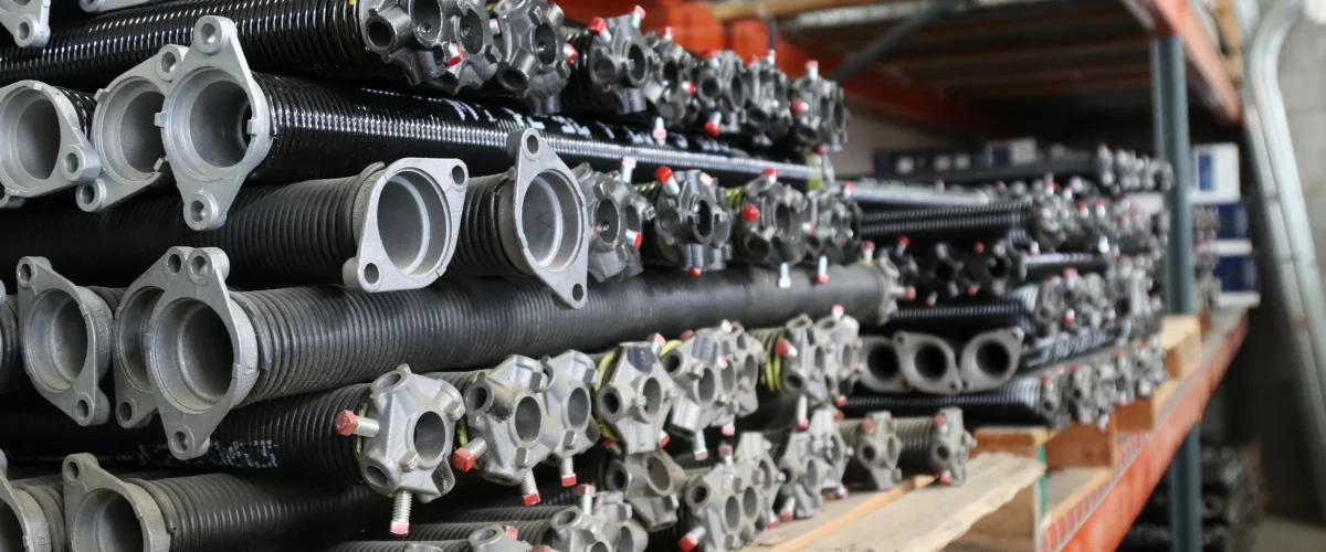 A close-up view of a beige garage door section with horizontal metal panels and a circular red warning sticker.