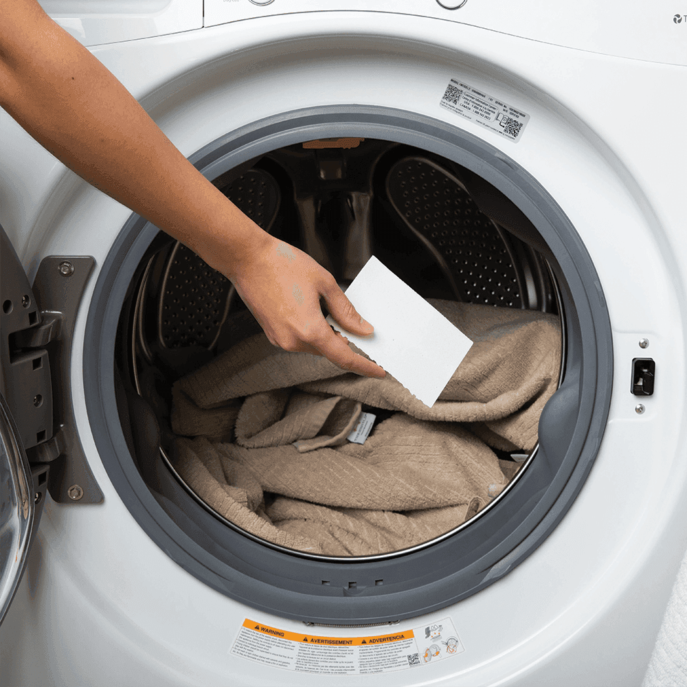 Professional cleaner wiping glass with foamy spray