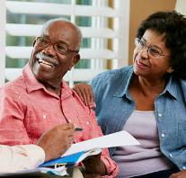 Senior couple signing reverse mortgage documents