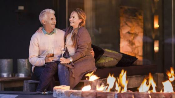 Senior couple relaxing by a fire pit, enjoying life on their terms
