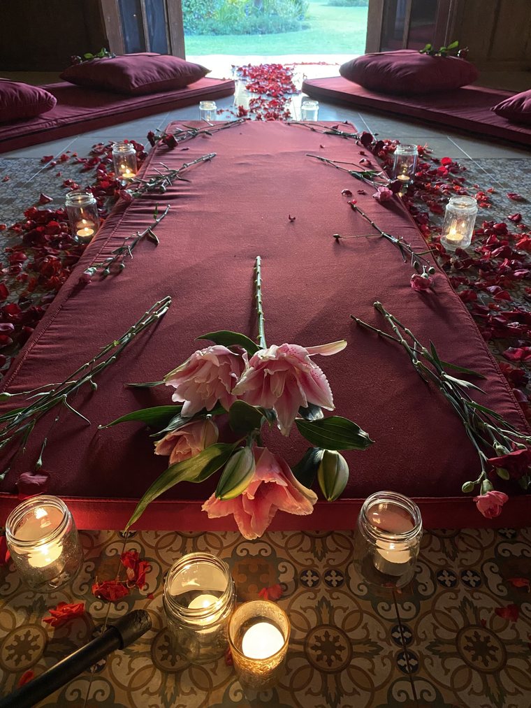 Pink lilies and candlelight along the length of the cloth.