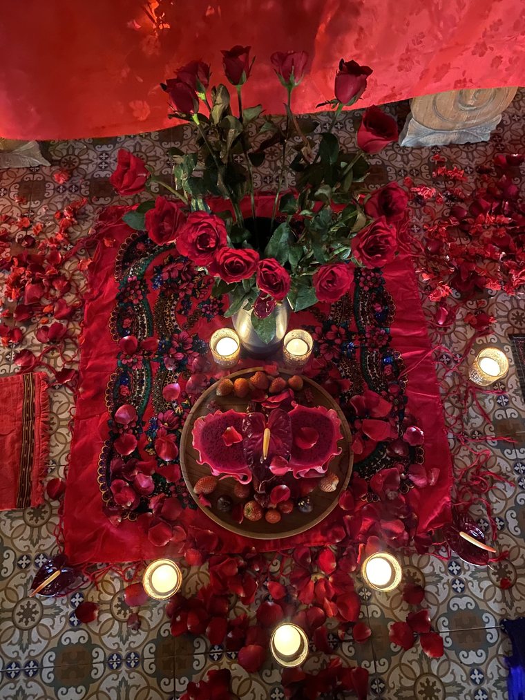 Red roses, candles and an offering plate on the ceremonial cloth.