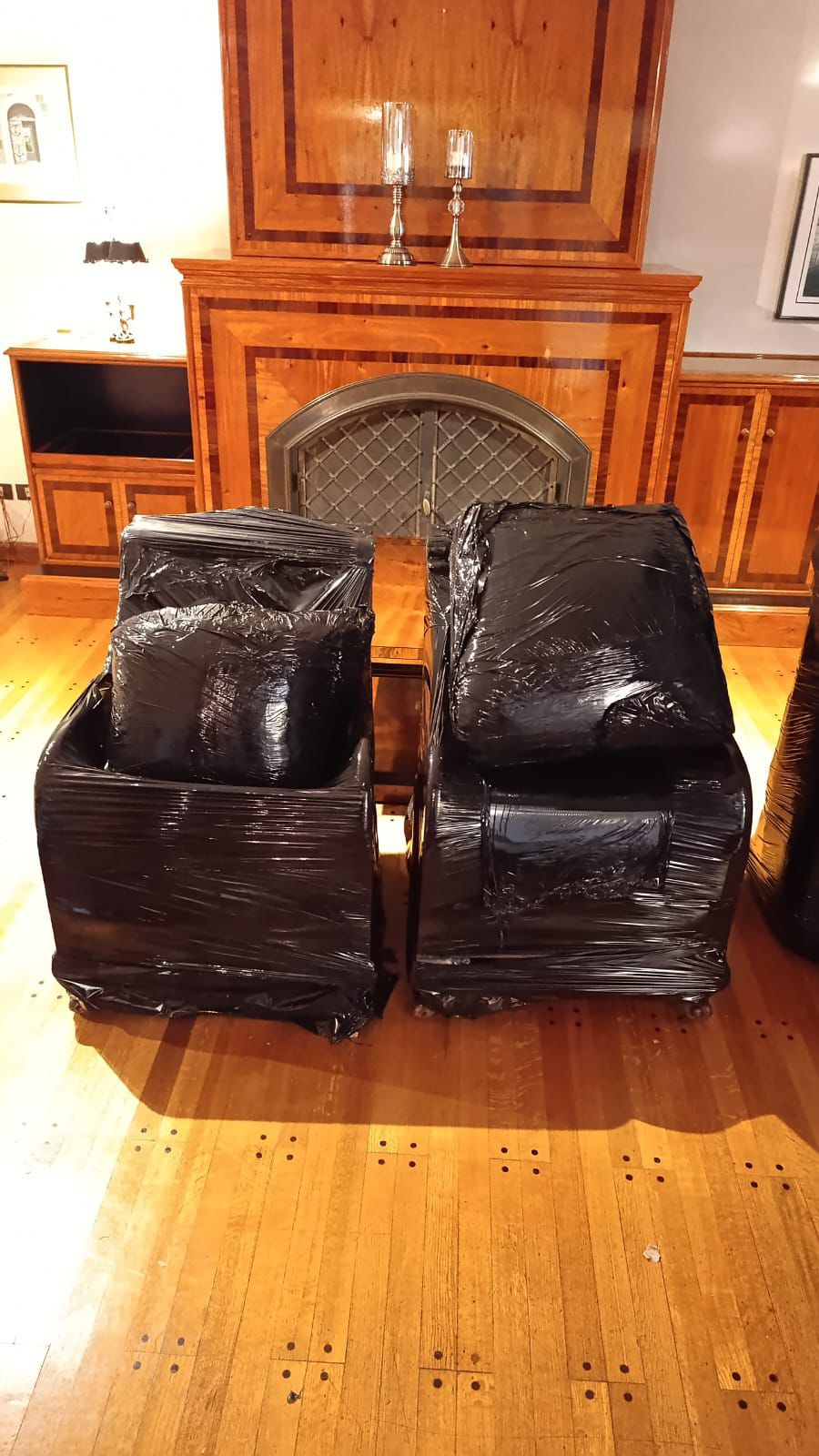 Dos sillones tapizados envueltos en film dentro de una vivienda