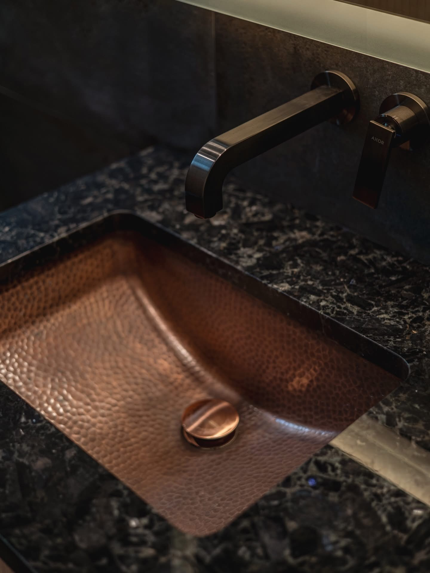 Hammered copper sink with matte black faucet and granite countertop