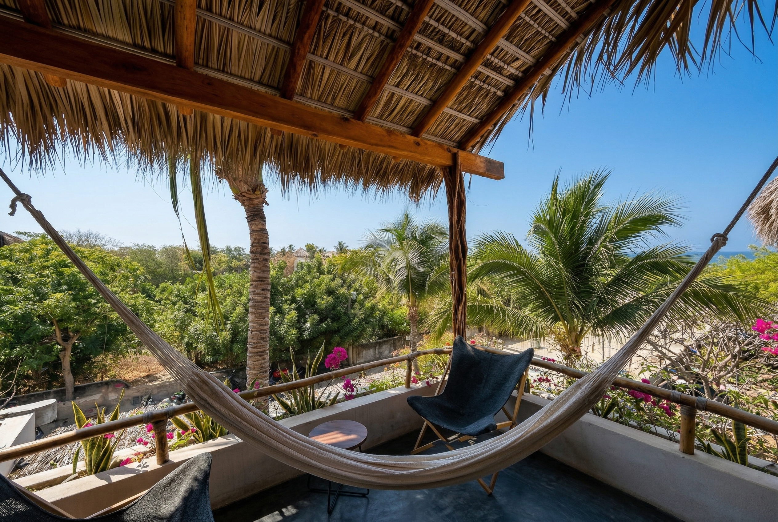 Private balcony with hammock and lounge chairs framed by palm trees