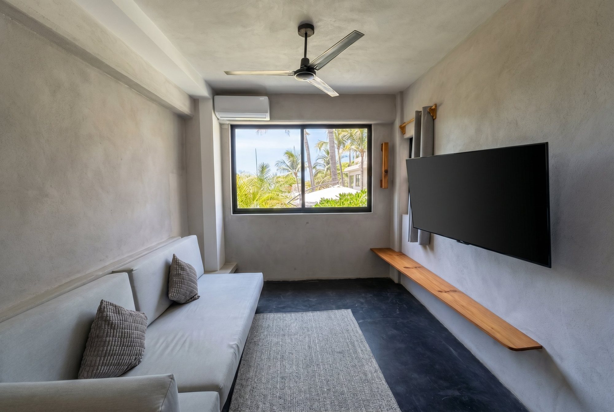 Living area with built-in seating, a smart TV, and palm views