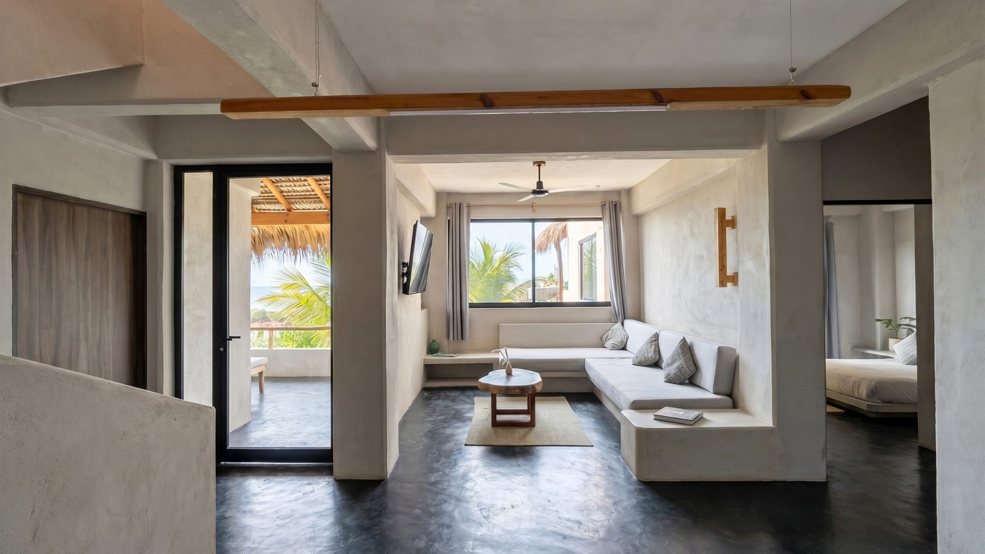 Living room with built-in seating, smart TV, and ocean glimpses through the window