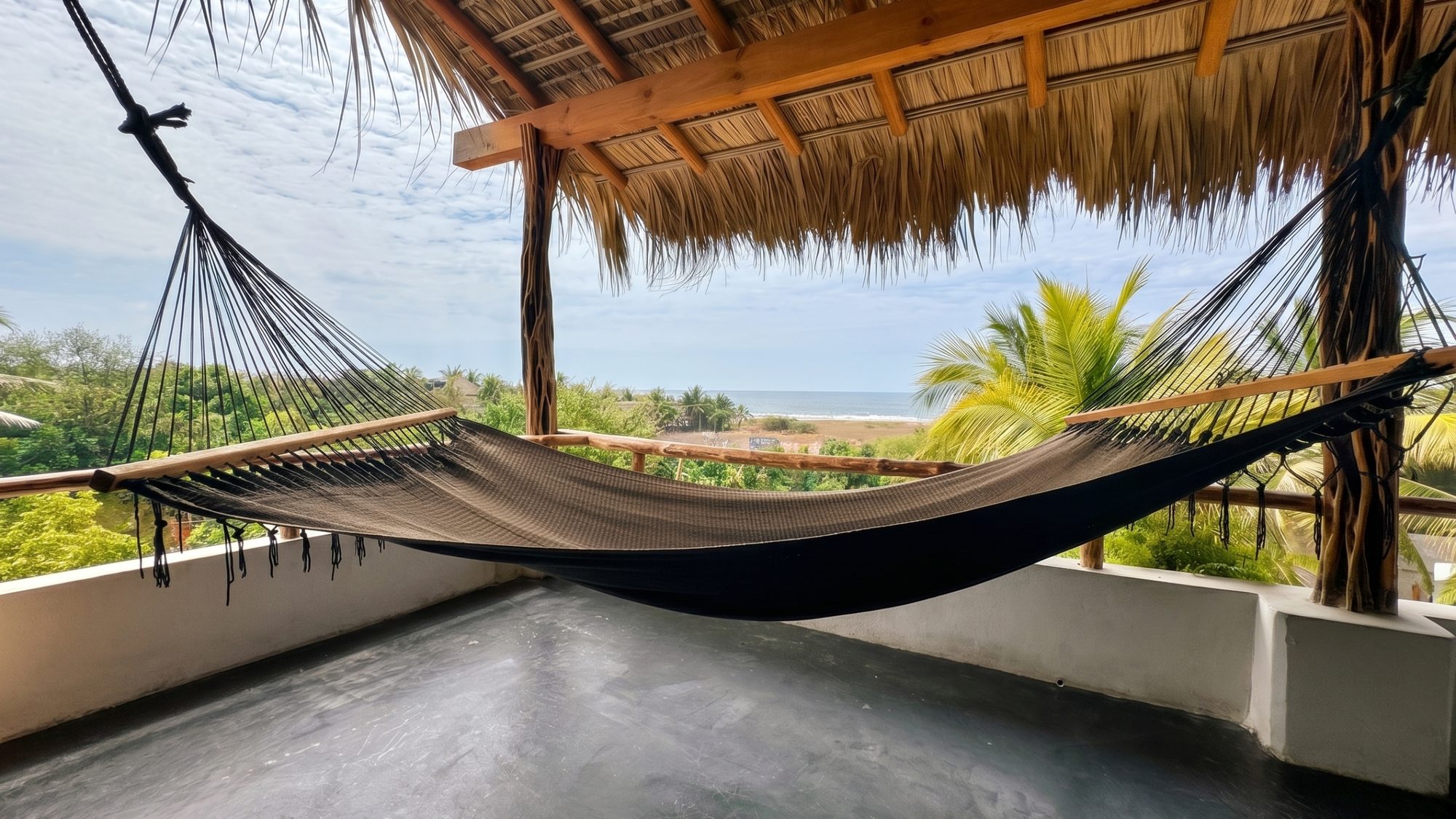 Private rooftop with a hammock and ocean views beneath a palapa roof