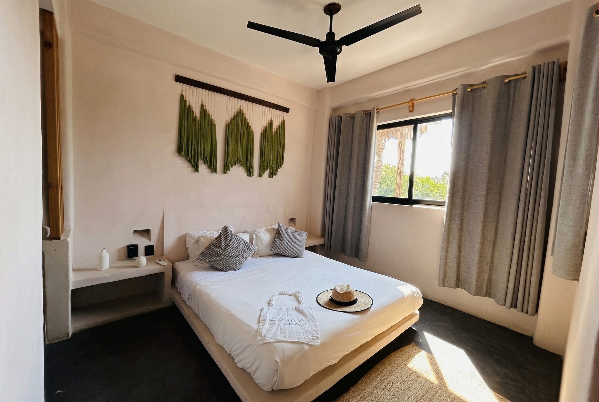 Bedroom with a king bed and green macramé wall art
