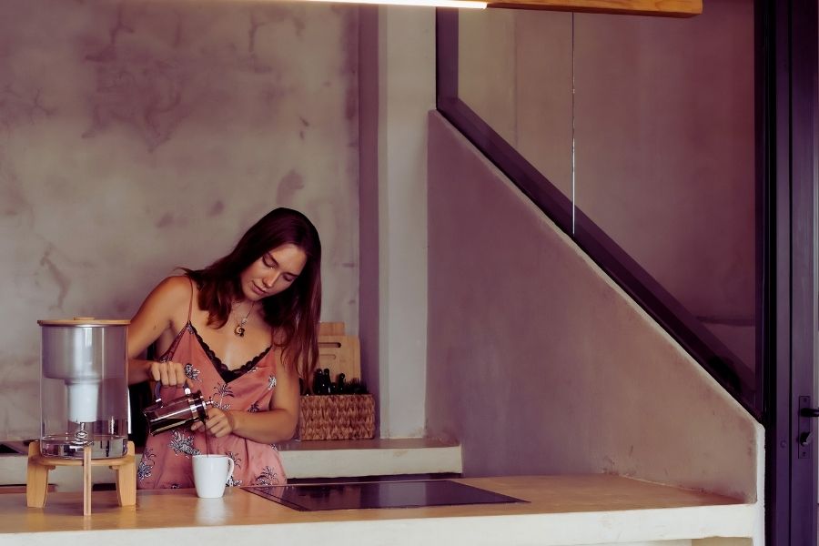 Guest pouring fresh coffee with a French press in the suite kitchen at Casa Leah