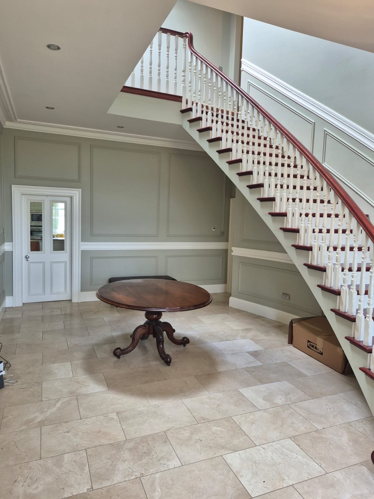Grand painted staircase with mahogany handrail in a panelled hallway, by Gary Creane Carpentry