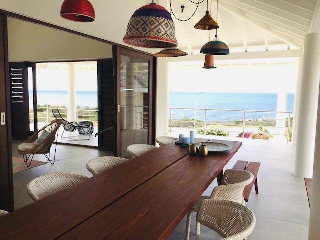 Lange houten eettafel met uitzicht op zee
