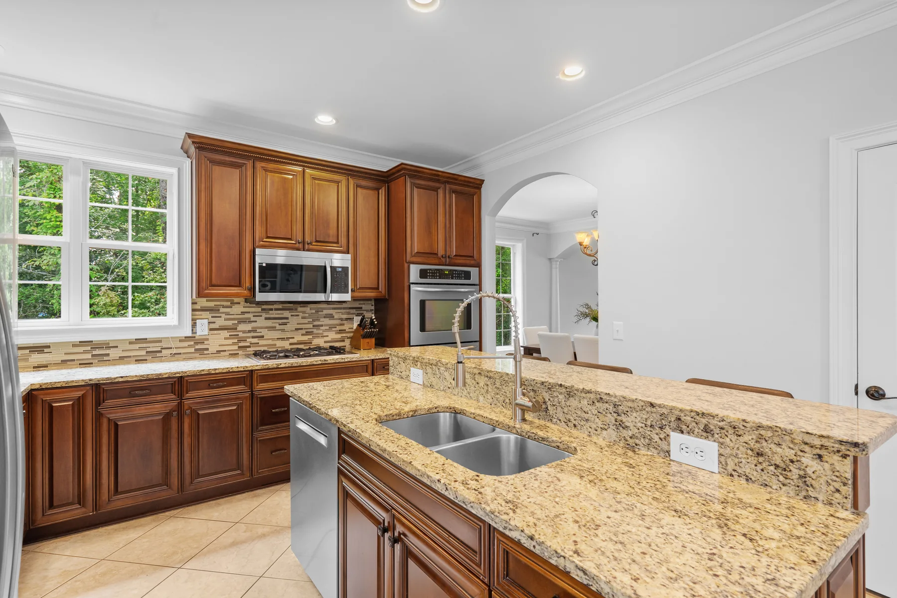 Kitchen with wooden cabinets, a granite countertop, and stainless steel appliances