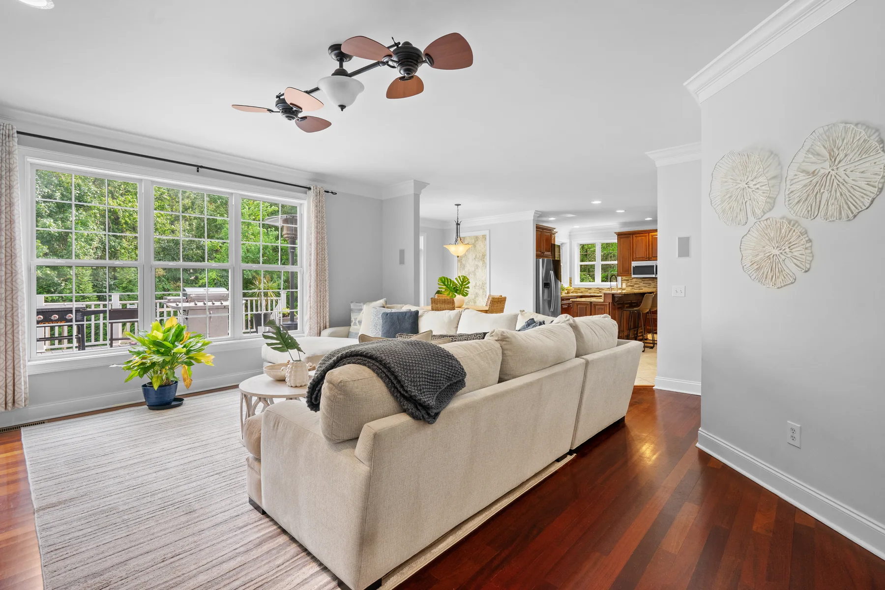 Living room with a large window and a kitchen with a bar counter in the background