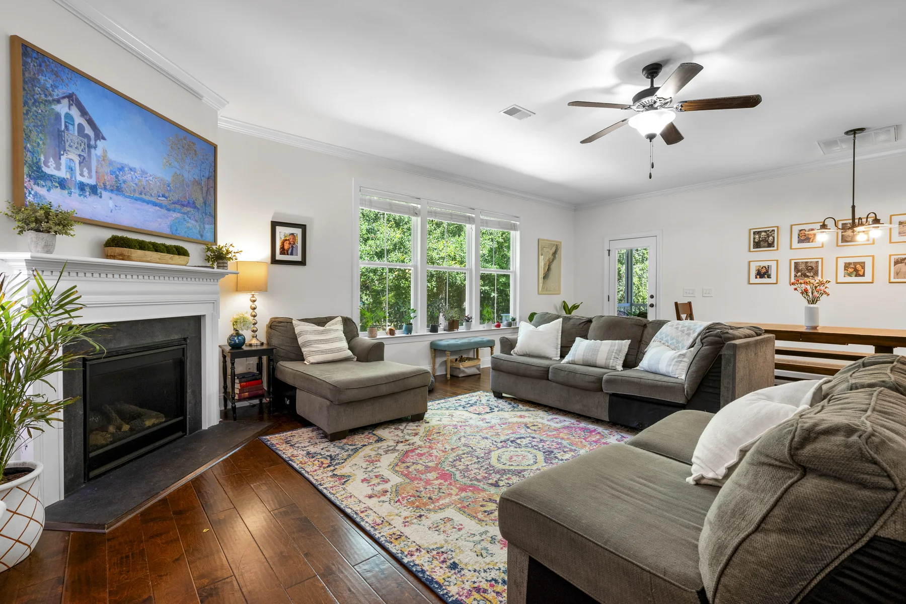 Living room with a fireplace, large wall art, and two couches on hardwood floors