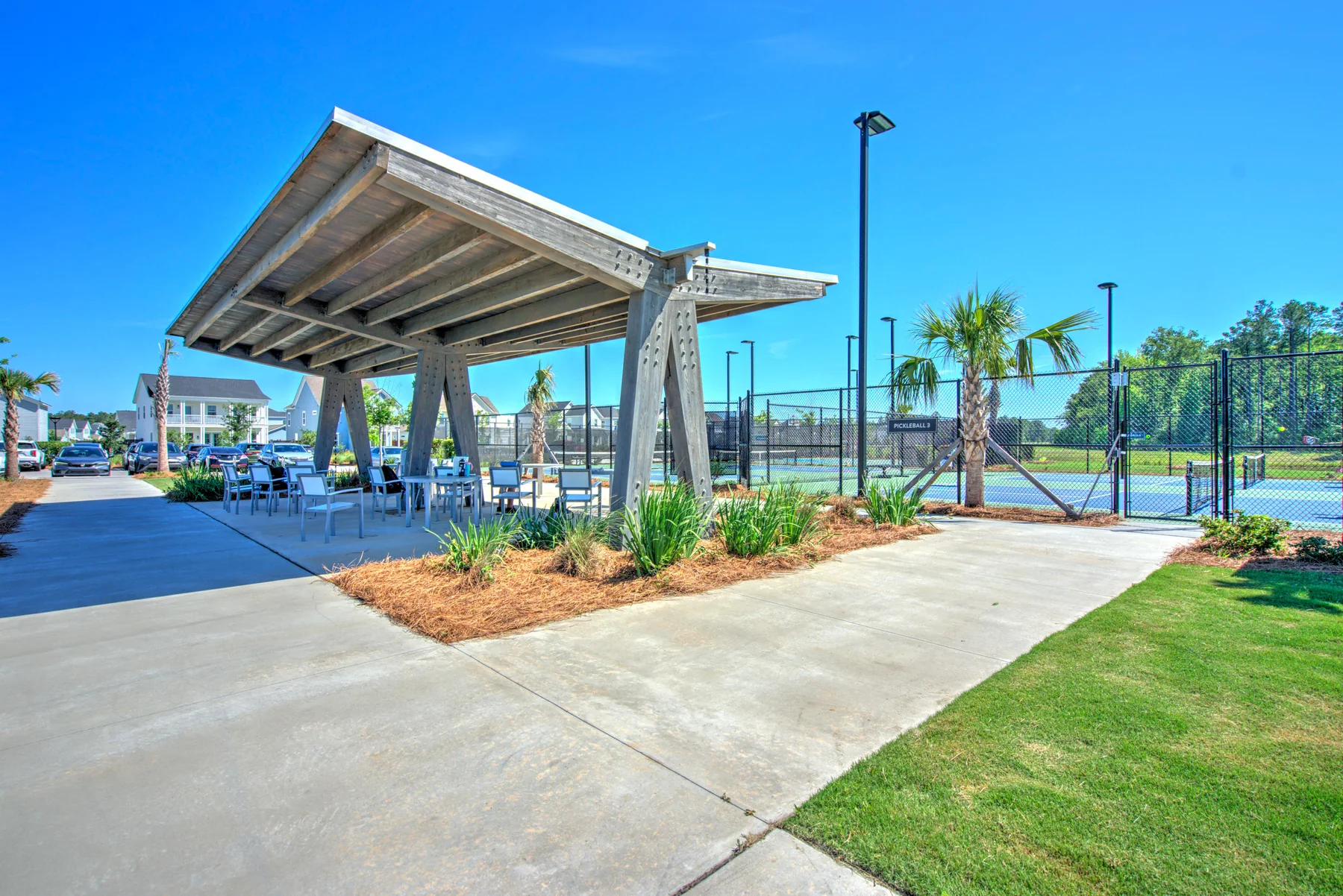 Aerial drone photo of a community pavilion with homes and trees in the background