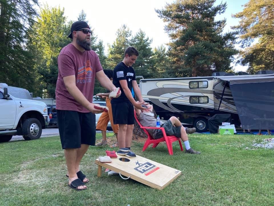 Family playing cornhole at the campsite