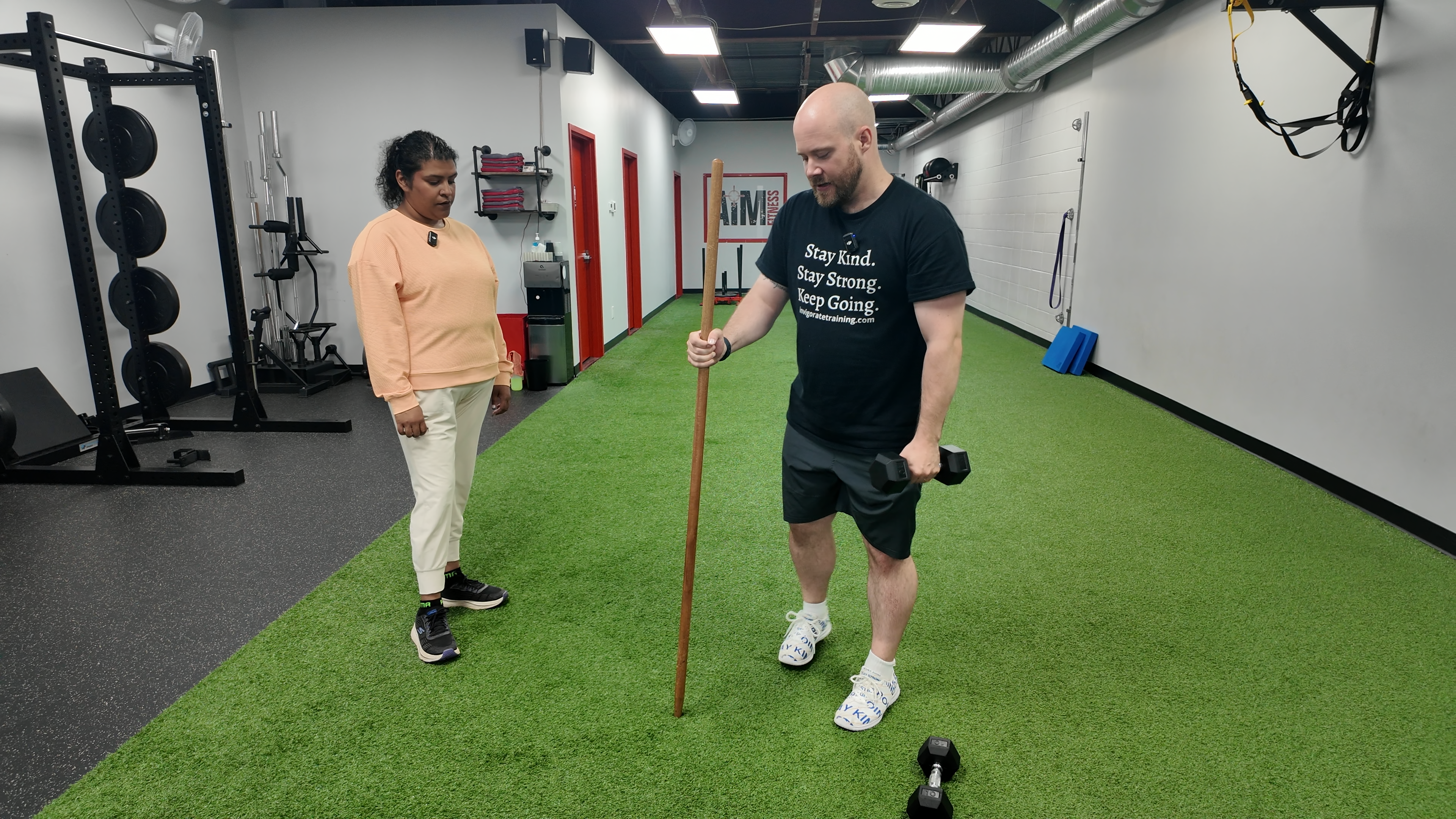 Coach Chris Liddle guiding a client through a strength exercise at AIM Fitness