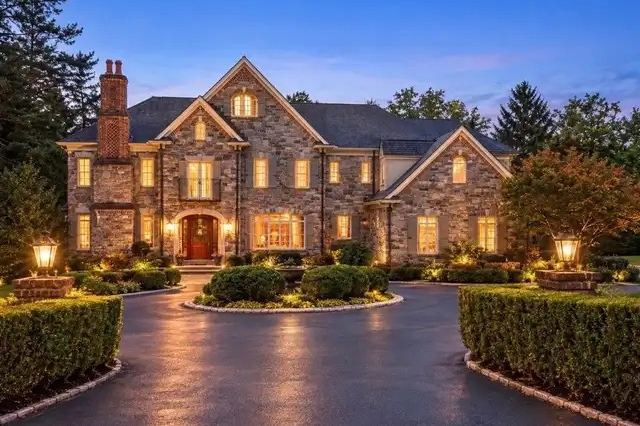 Stone colonial with a circular driveway at dusk on the Main Line