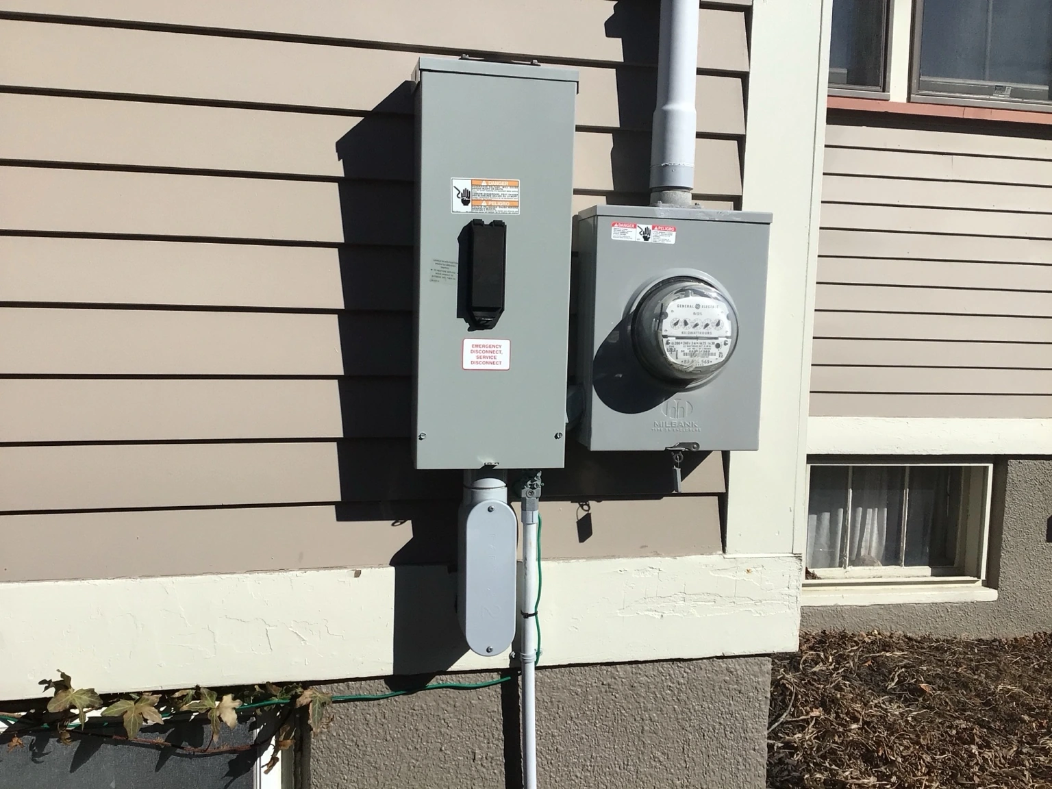 Exterior electrical meter and service equipment installed beside a home