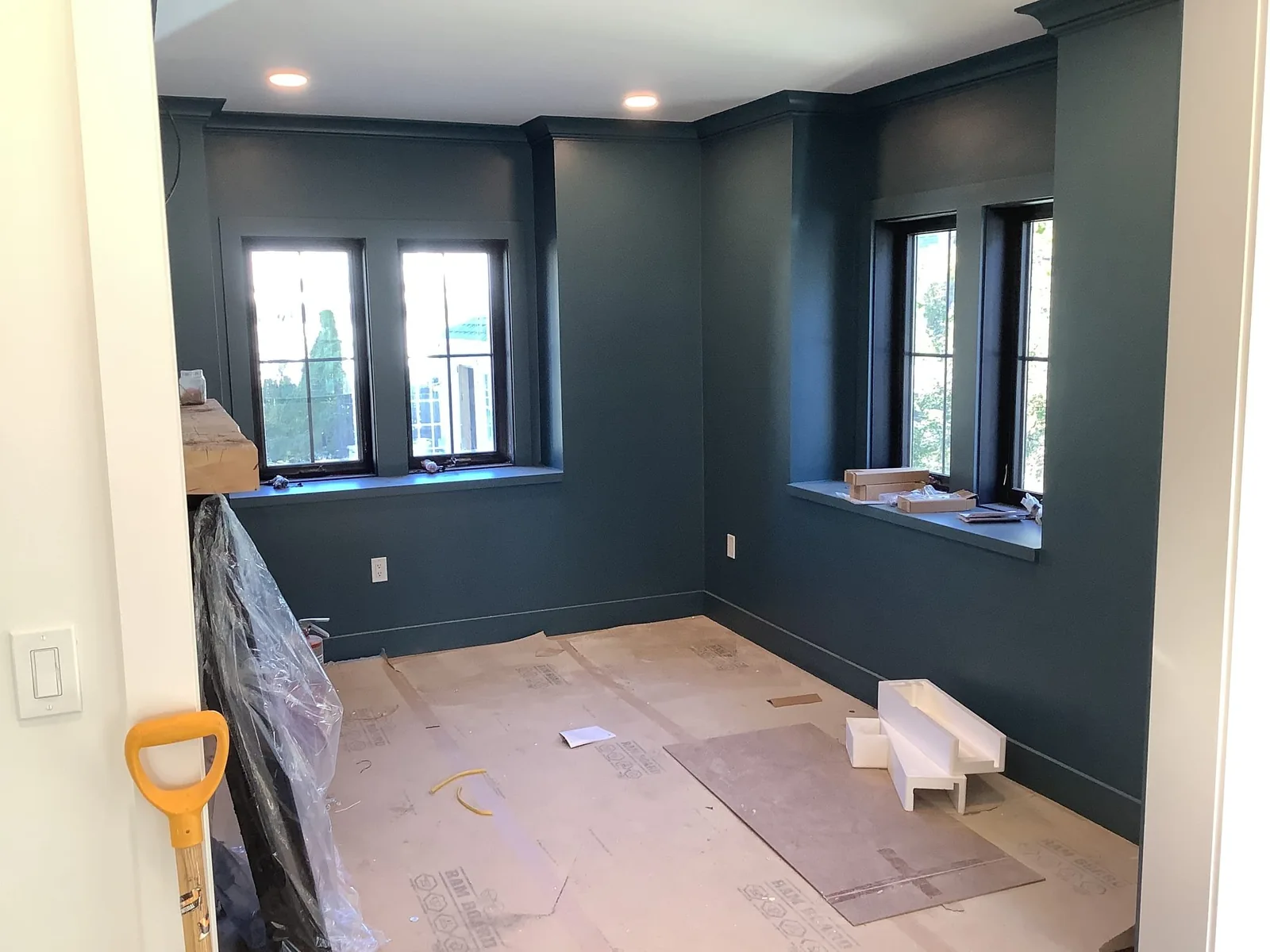 Painted room with recessed ceiling lights and protected flooring