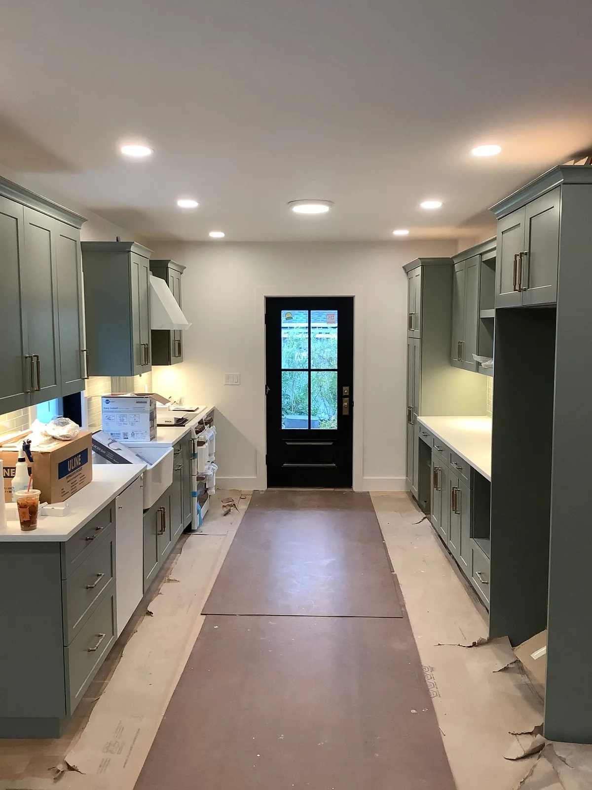 Remodeled kitchen with illuminated recessed lighting and floor protection