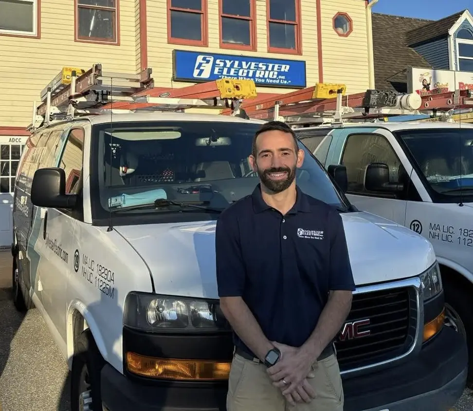 Sylvester Electric technician standing in front of company service vans