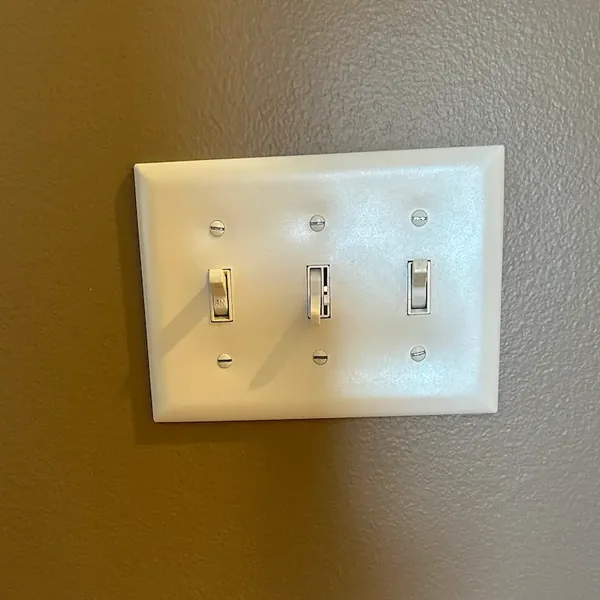Wall switches and a slide control fitted into a three-gang wallplate