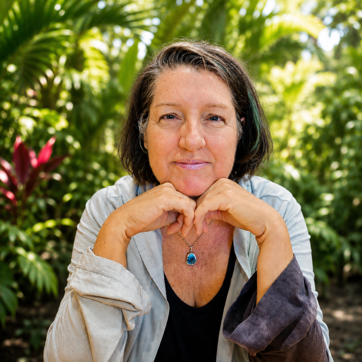 Tanja resting her chin on her hands in front of greenery