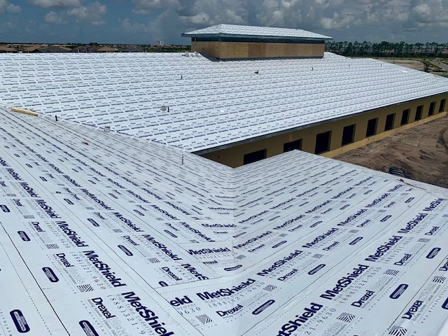 Large commercial building roof deck prepared with metal roofing underlayment