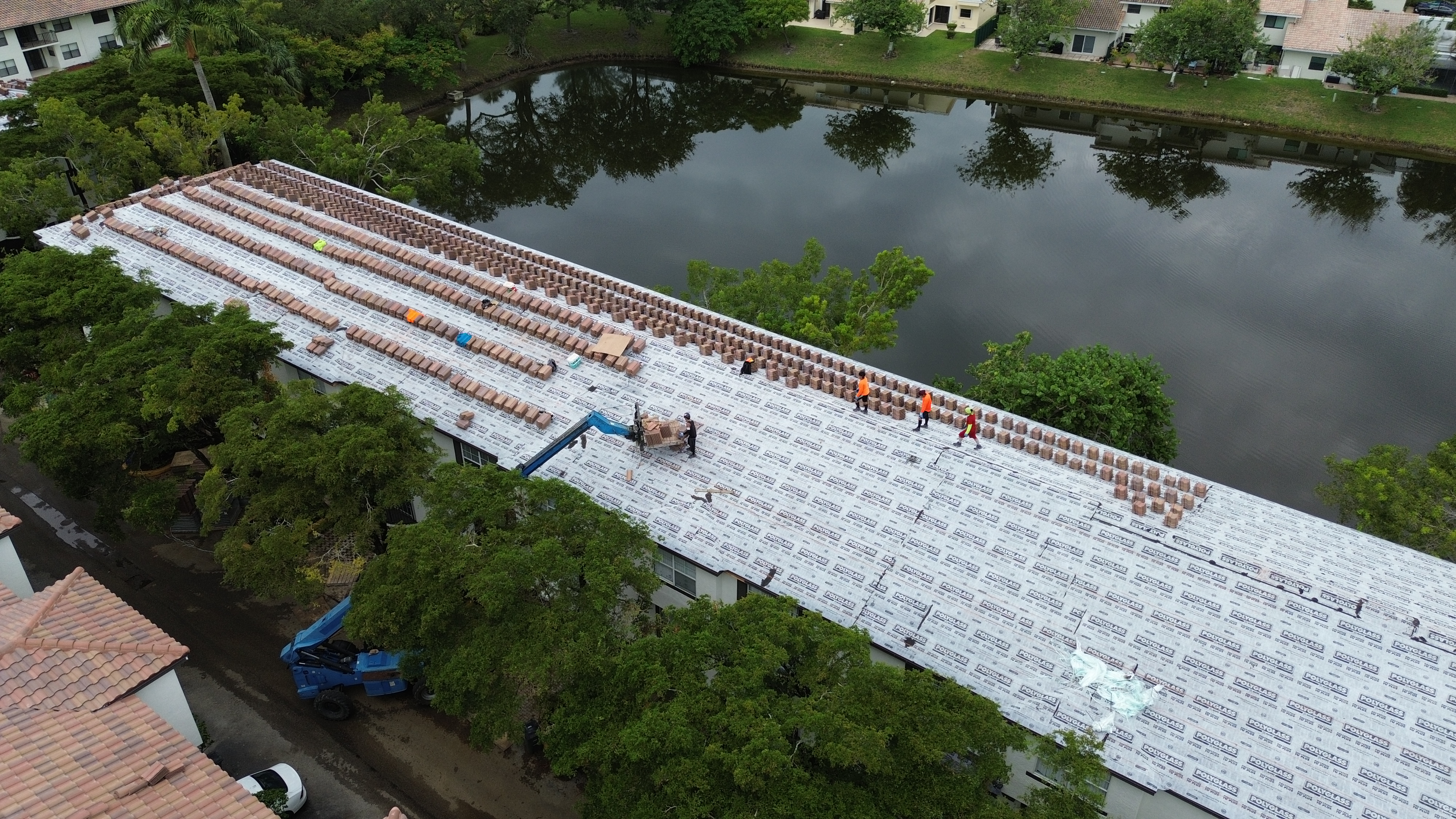 Aerial view of a large occupied re-roof in progress with crews working across new roof underlayment