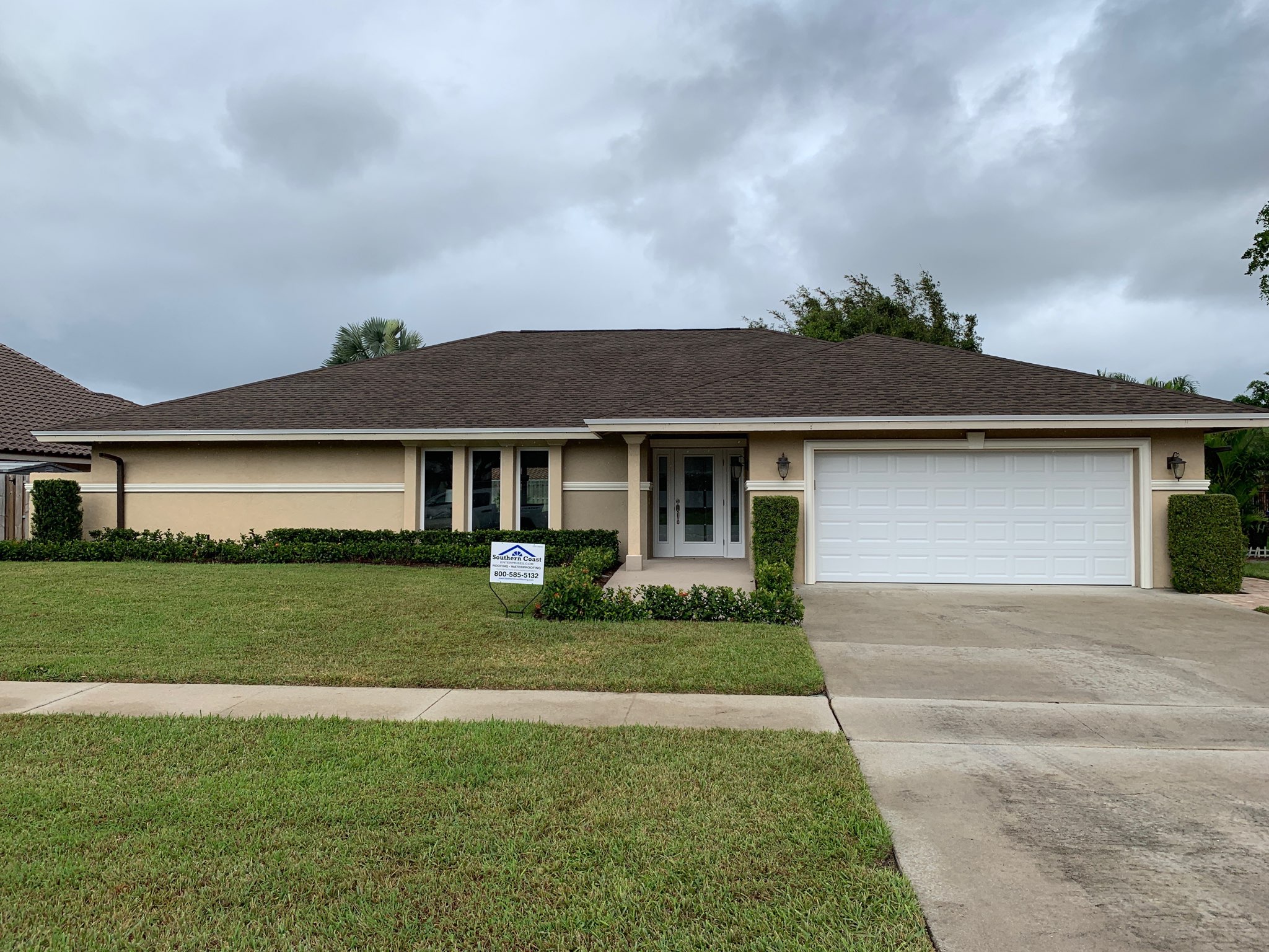 Completed architectural shingle roof on a South Florida home with a Southern Coast Enterprises yard sign