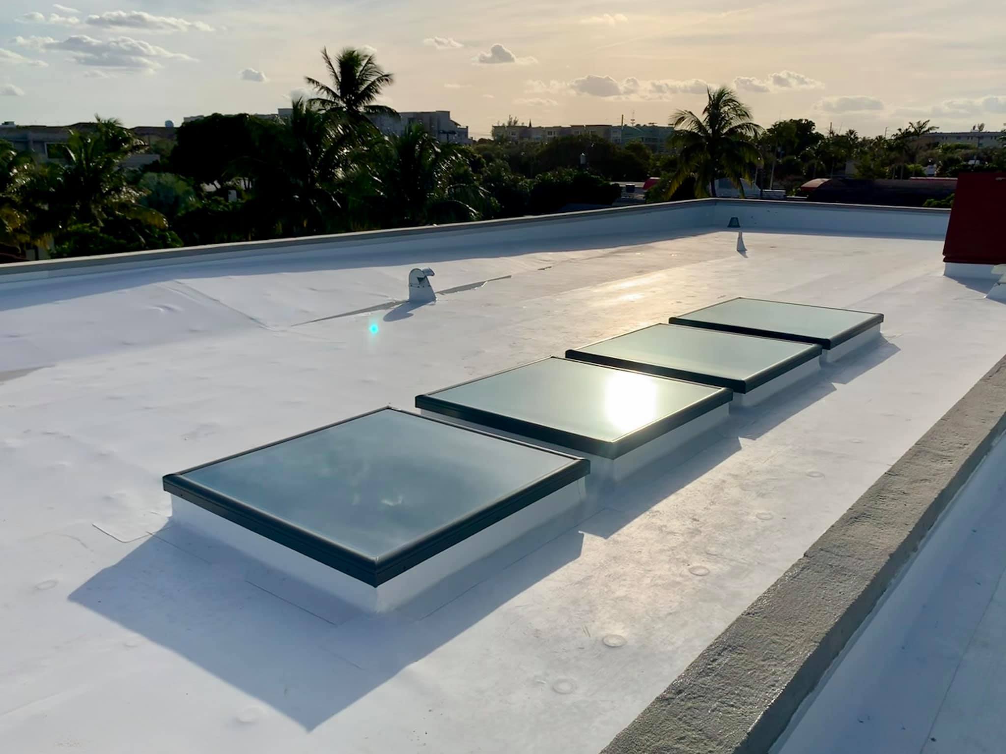 White waterproof coating across a flat roof with skylights