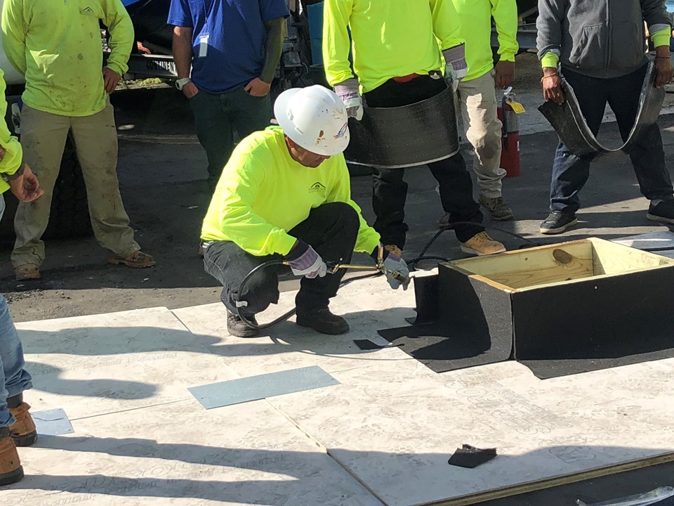 Crew member practicing a roofing detail on a training mock-up