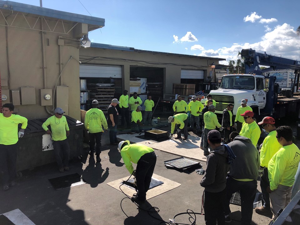 Southern Coast crew members gathered around roofing training mock-ups