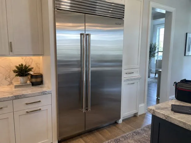 Sub-Zero style built-in refrigerator photographed after repair in a customer kitchen