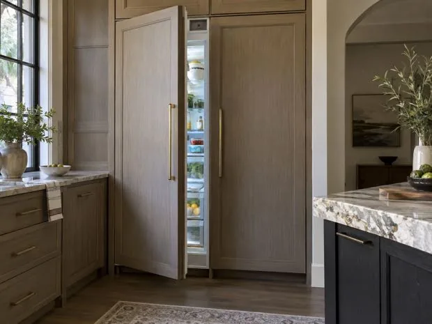 Integrated panel-ready refrigerator photographed after cooling repair in a customer kitchen