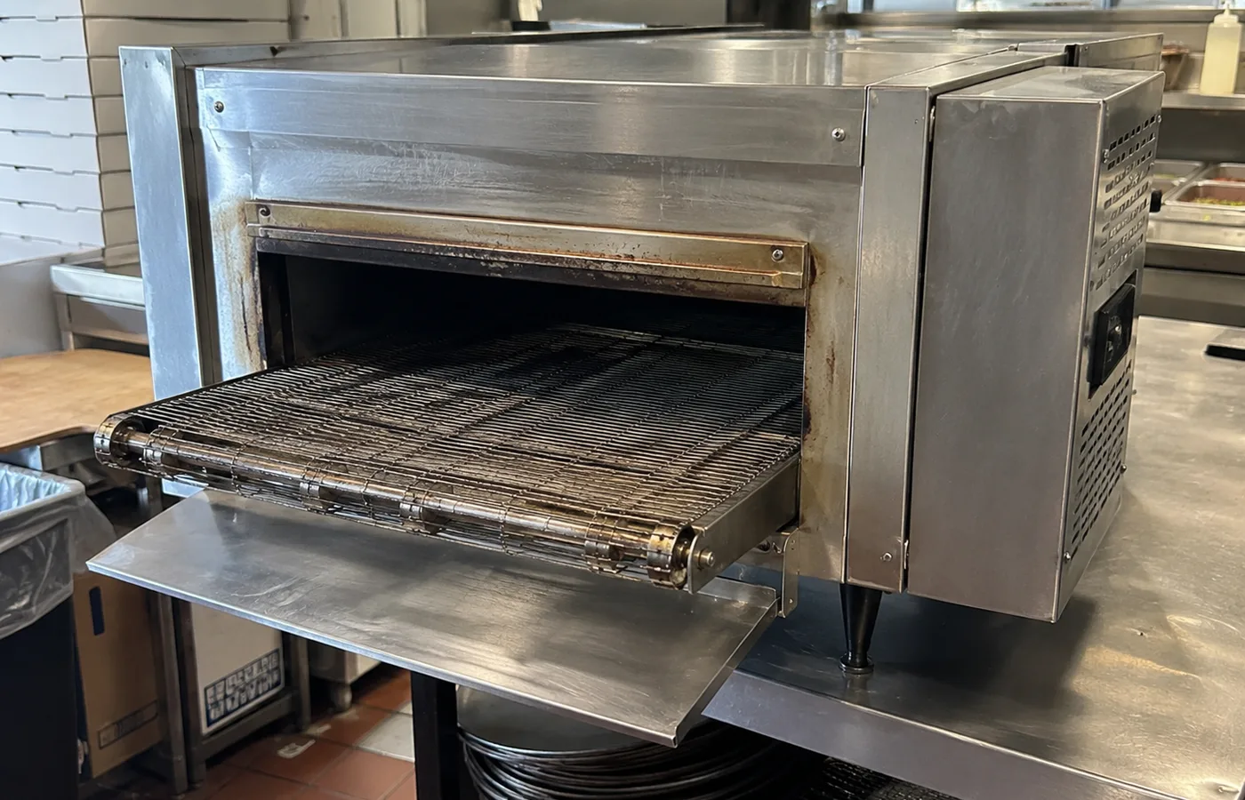 Compact conveyor oven ready after belt-speed service
