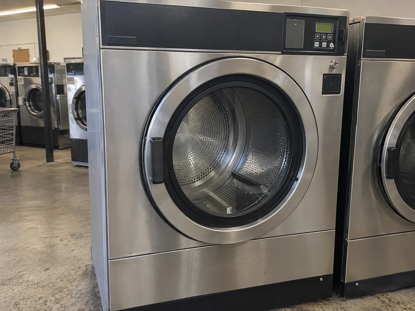 Front-load commercial dryer after drum rotation repair in a working laundromat
