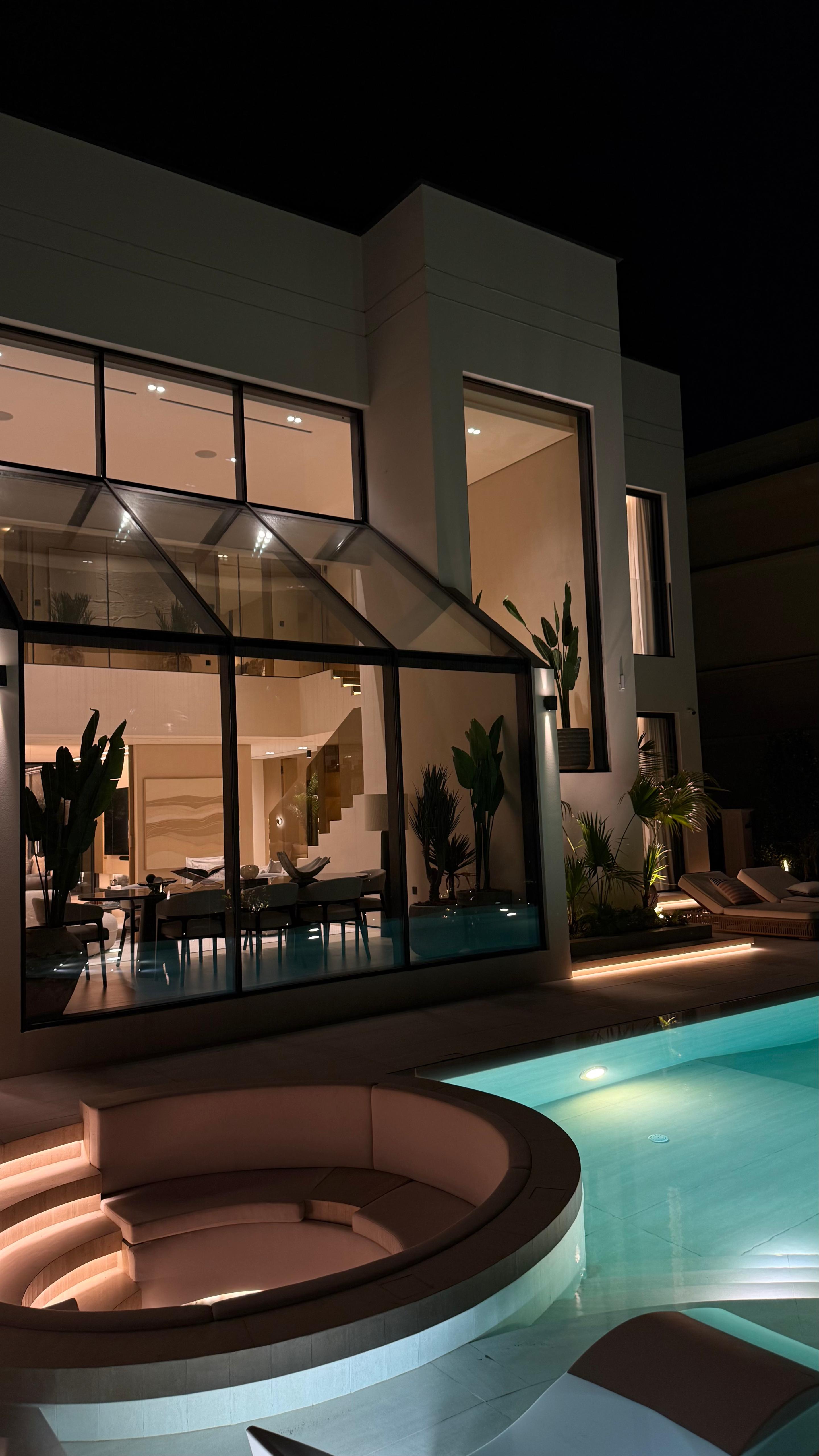 An illuminated terrace and swimming pool in the evening