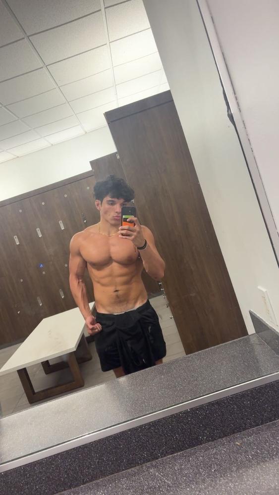 Sergio posing in the gym locker room showing a lean physique