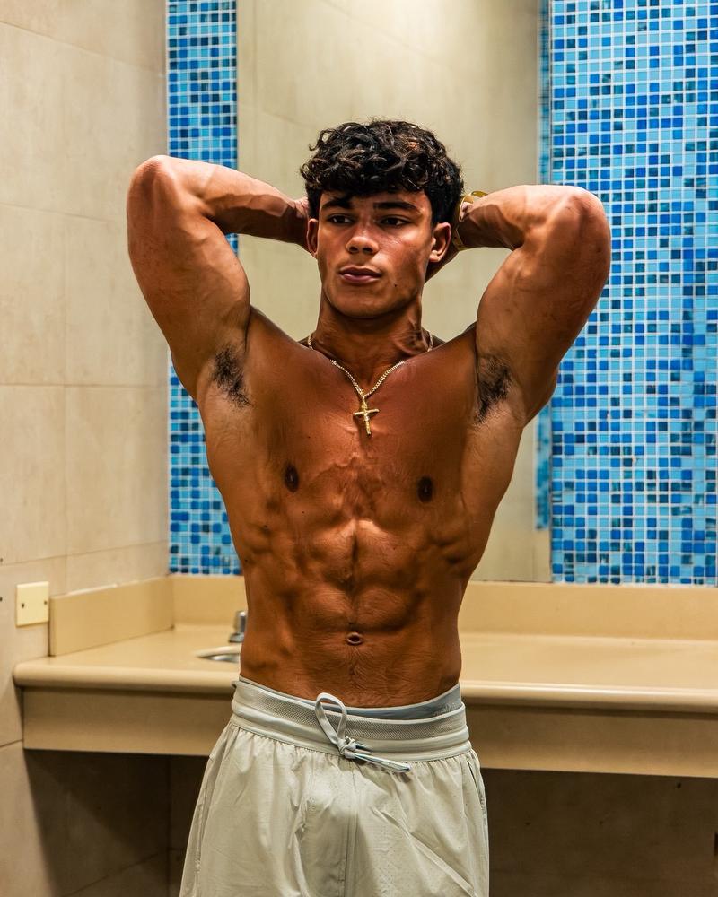 Sergio in a rear-and-arms pose highlighting muscle development