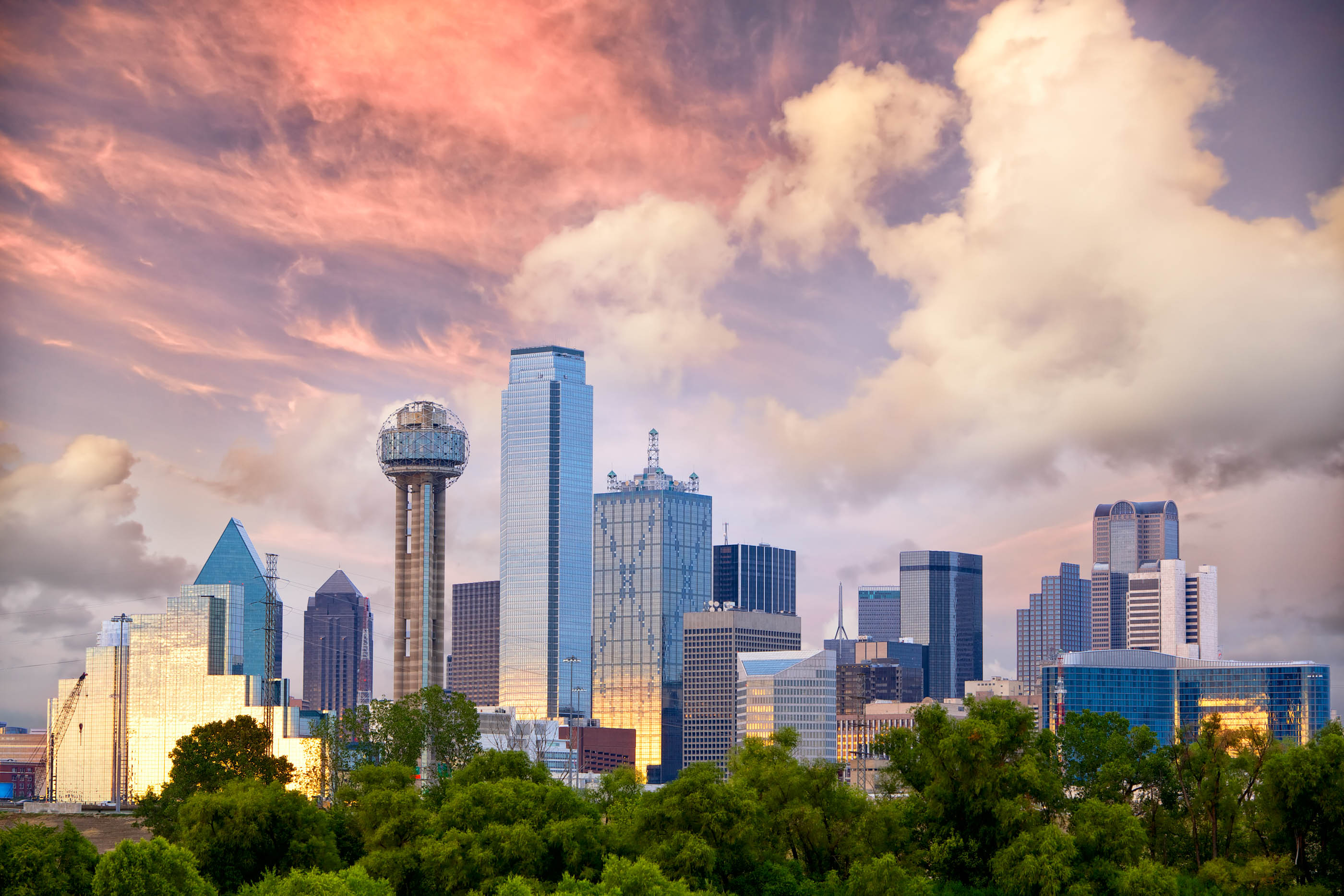 Dallas skyline with Reunion Tower under big pink clouds, serving McKinney and DFW