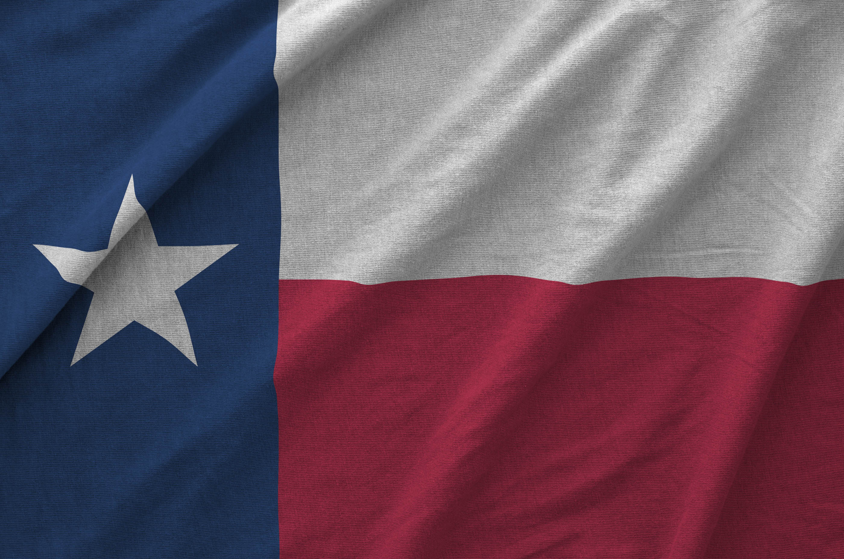 Close-up of a Texas flag's fabric showing the red, white and blue weave