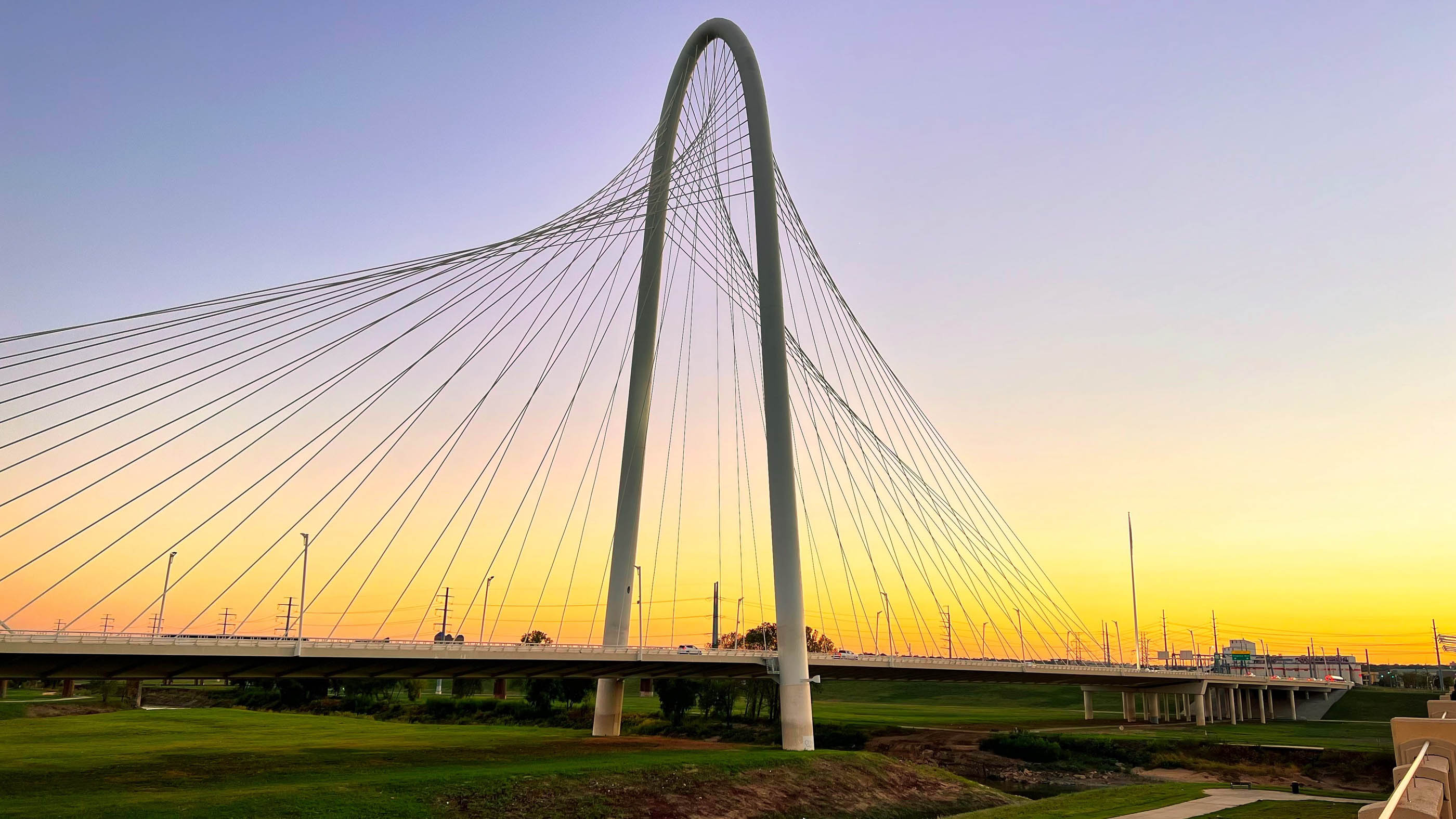 Margaret Hunt Hill Bridge against a gold sunset sky