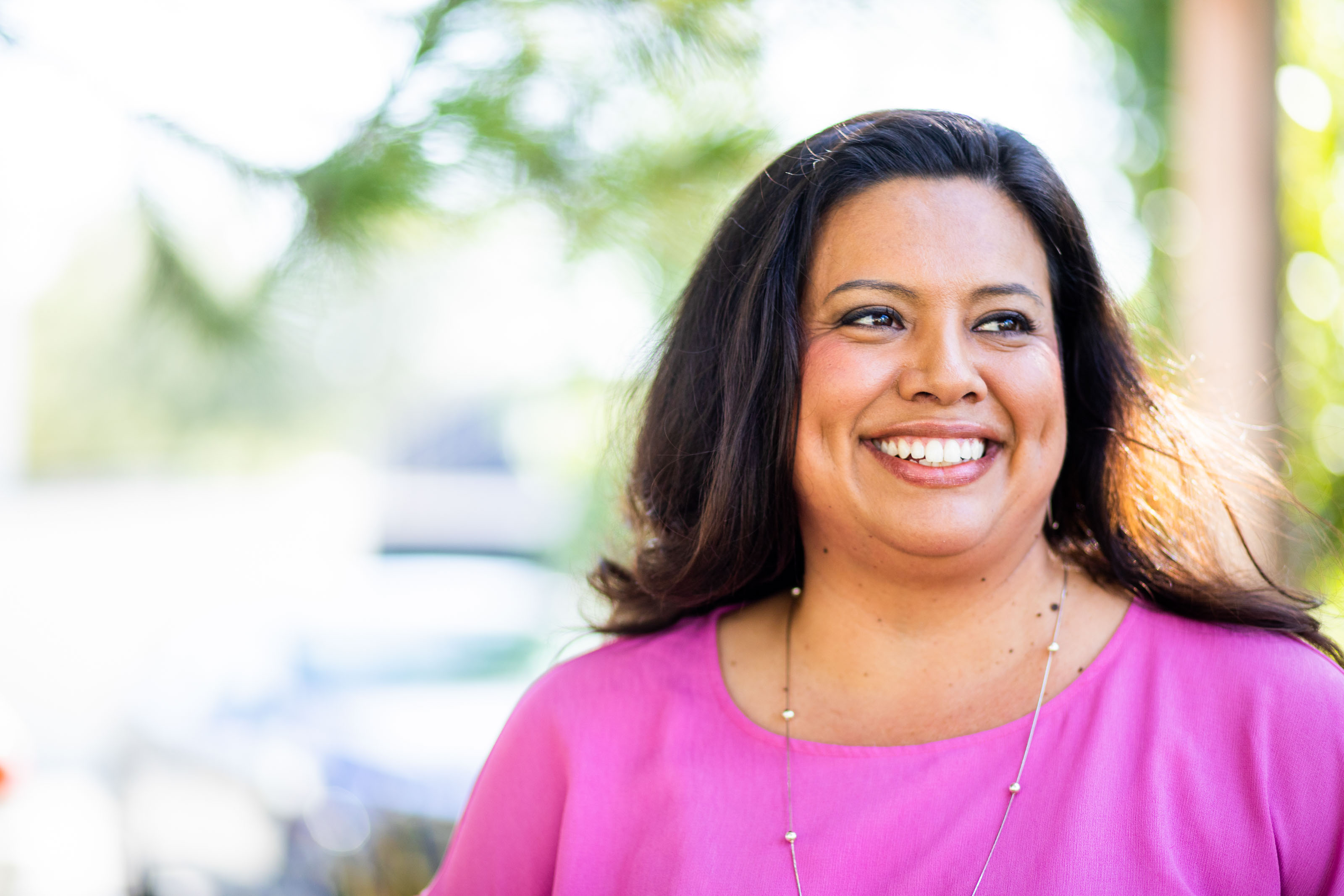 Laughing woman in a magenta top outdoors
